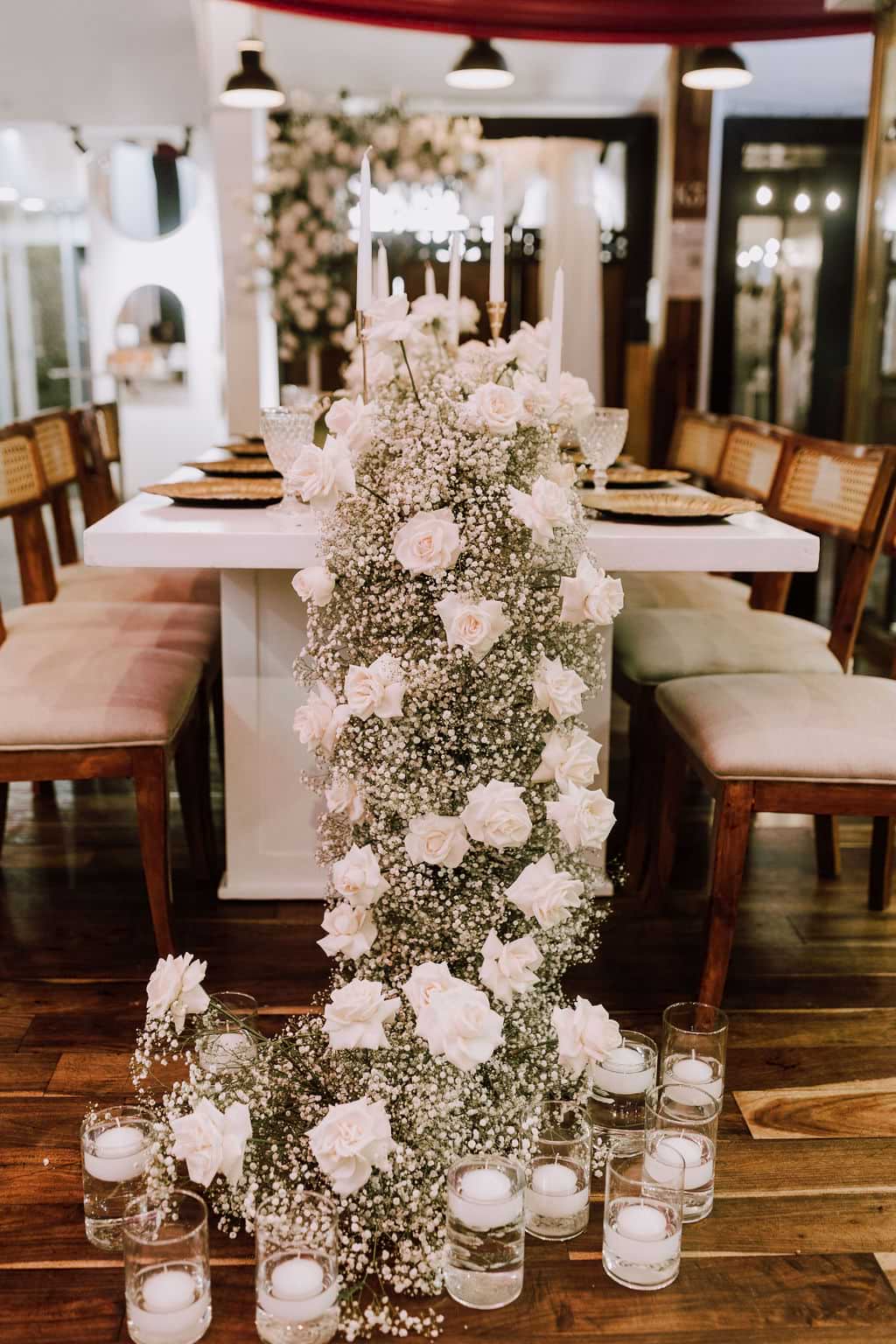 Rosas y otras flores blancas en arreglo floral para fiesta.